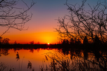 Summer sunset or sundowner view with reflections in a pond near Aholming, Deggendorf, Bavaria, Germany