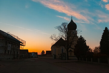 Spring sunset or sundowner with a church silhouette seen from near Arbing, Osterhofen, Deggendorf,...