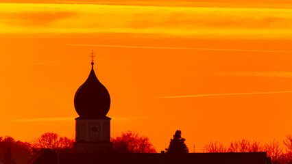 Spring sunset or sundowner with a church silhouette seen from near Arbing, Osterhofen, Deggendorf,...
