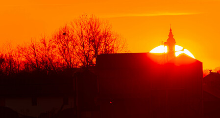 Spring sunset or sundowner with a church silhouette seen from near Arbing, Osterhofen, Deggendorf,...