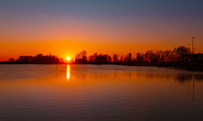 Naklejka premium Spring sunset or sundowner view with reflections near Plattling, Isar, Deggendorf, Bavaria, Germany