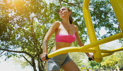 A young woman are exercising on a machine in a park