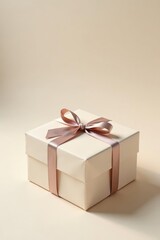 Obraz premium A delicately wrapped present, a square box adorned with a blush-toned satin ribbon, sits on a neutral backdrop, ready for a special occasion.