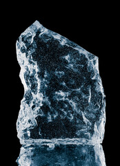 Plakat Crystal clear frosty textured natural ice block on a black mirroring surface.