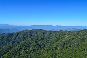 Obraz premium Distant Mountains and Forest with Trees and Sky in Northern Thailand.