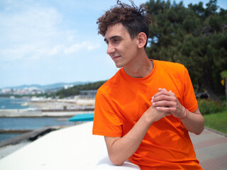 A young attractive student is walking on the embankment.