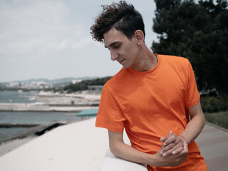 A young attractive student is walking on the embankment.