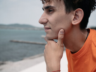 A young attractive student is walking on the embankment.