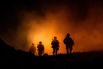 Silhouette of soldiers moving in a smoky fiery environment at night