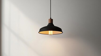 Black pendant lamp against a white wall, casting shadows
