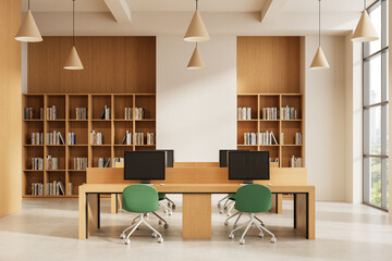 Modern library interior with wooden desks, green chairs, bookshelves, and computers in bright open space with large windows and pendant lights. 3D Rendering
