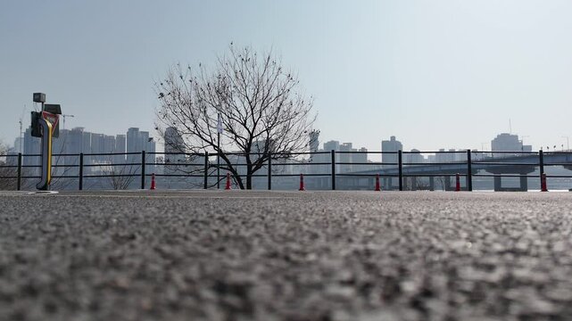 Urban Cyclist Riding Along Han River Bike Path &ndash; Low-Angle Silhouette View

