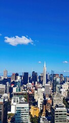 Vibrant City Skyline Under Bright Blue Sky with Sharp Lines and Colors