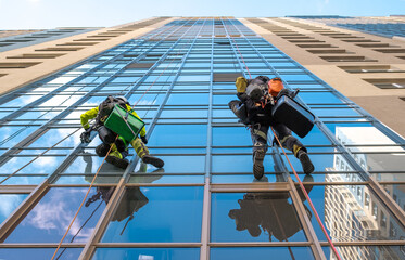 Rope access specialist washes the facade of a building