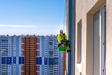 Rope access specialist washes the facade of a building