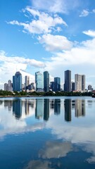 Fototapeta premium Stunning City Skyline Reflected in Serene River Under Blue Sky