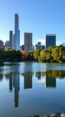 Fototapeta premium Reflections of Modern City Skyline in Calm Lake Surrounded by Park