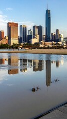 Obraz premium Skyscrapers Reflecting in Water Under Clear Sky in Urban Area
