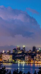 Fototapeta premium Vibrant City Skyline at Dusk with Lights and Low Cloud Reflections