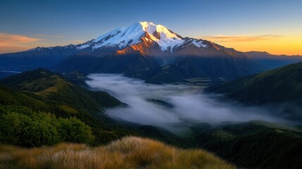 A stunning view of a snow-covered mountain rises above a lush valley, with soft clouds swirling around at sunset. The landscape radiates calm and serenity