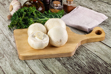 White champignon mushrooms heap over board