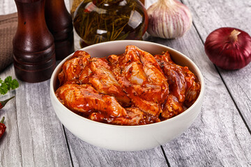 Raw marinated buffalo chicken wings