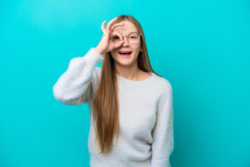 Young Russian woman isolated on blue background showing ok sign with fingers