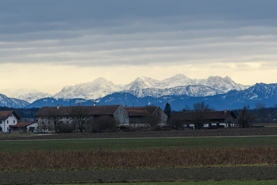 Ort vor verschneiten Alpen in Oberbayern im Winter