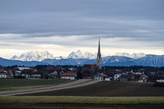 Ort vor verschneiten Alpen in Oberbayern im Winter