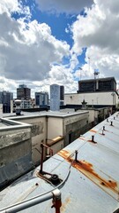 Fototapeta premium Rooftop View with City Skyline Under Dramatic Cloudy Sky