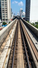 Naklejka premium Urban Rooftop View of Train Track under Bright Blue Sky