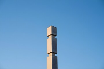 Abstract Structure against Blue Sky: A striking, minimalist concrete structure ascends into the cerulean expanse, its geometric forms creating a compelling visual narrative.