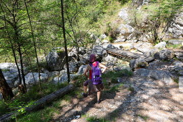 Young woman with rucksack on her shoulders in the path in mountain