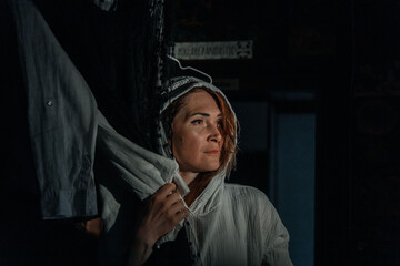 Contemplative young caucasian female in hooded jacket amidst dark setting