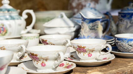 Vintage teacups and saucers with floral patterns arranged on a wooden table
