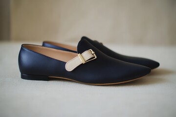 Pair of elegant, dark navy loafers with a light beige accent.