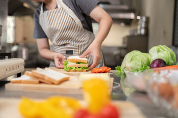 Chef preparing fresh sandwiches in a kitchen culinary scene vibrant ingredients engaging viewpoint