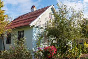 A small wooden country house on a summer street.