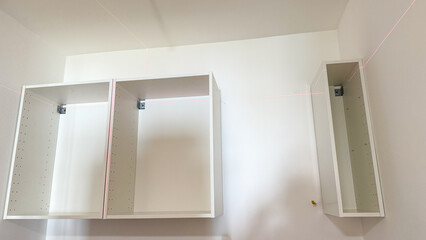 Bare white cabinets float like minimalist ghosts, evoking Tidy Tuesday and National Organize Your...