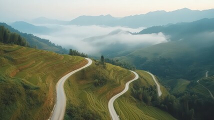 Fototapeta premium High Elevation Photo of Winding Rice Terrace with Fog and Mountains at Sunrise