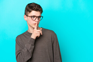 Teenager Russian man isolated on blue background showing a sign of silence gesture putting finger...