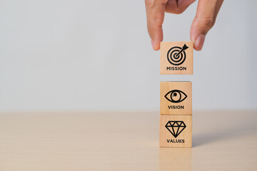 Mission, vision and values of company. Purpose business concept. Hand holds wooden cube with...