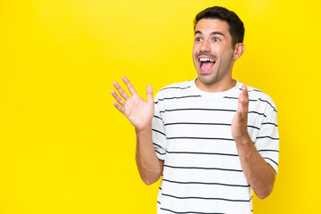 Young handsome man over isolated yellow background with surprise facial expression
