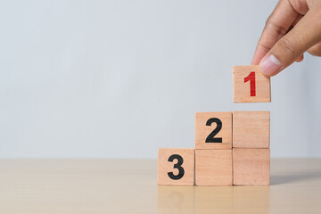 Wooden cube blocks with number first, second, and third. Task priority and management concept. The...