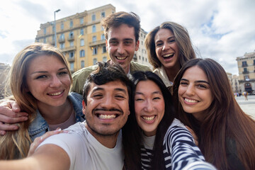 Diverse young people having fun at city street during vacation. Group of cheerful multi-ethnic...