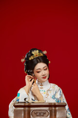 Girl wearing Chinese Ming Dynasty Hanfu costume against a red background