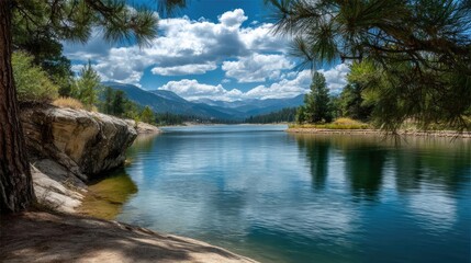 Scenic view of lake in pine forest with mountain and park concept. A serene lake surrounded by lush trees under a blue sky.