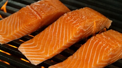 Close-up of Delicious Salmon Fillets on a Grill with Roaring Flames