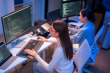 Professional computer engineer working on a new software technology design in the office Night,...