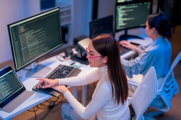Professional computer engineer working on a new software technology design in the office Night,...